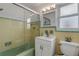 Retro bathroom with mint green and yellow tile, shower, and vanity at 1232 Bel Aire Dr, Daytona Beach, FL 32118