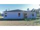 Rear view of a single story house with covered patio and grassy yard at 3177 Sw 127Th St, Ocala, FL 34473