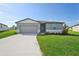 One-story home with gray siding, light-colored trim, and a two-car garage at 1717 Forest Run Ln, Auburndale, FL 33823