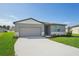 One-story home with gray siding, light-colored trim, and a two-car garage at 1717 Forest Run Ln, Auburndale, FL 33823