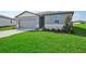 Front view of a one-story house with a neatly landscaped lawn at 1717 Forest Run Ln, Auburndale, FL 33823