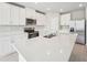 Spacious kitchen boasts white cabinets, quartz countertops, and stainless steel appliances at 1717 Forest Run Ln, Auburndale, FL 33823