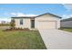 Single-story home with a two-car garage and landscaped lawn at 1752 Forest Run Ln, Auburndale, FL 33823