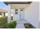 Front porch with light blue door, stone accents, and landscaping at 2719 Virginia Pine Dr, Bartow, FL 33830