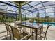 Covered patio with table and chairs overlooking pool at 5299 Wildwood Way, Davenport, FL 33837