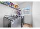 Convenient laundry room with washer, dryer, and shelving at 1233 Nelson Park Court, Poinciana, FL 34759