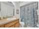 Bathroom with wood vanity, toilet, and seashell-themed shower curtain at 832 Valnera Ct, Kissimmee, FL 34758