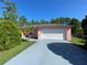 Pink house with a white garage door and a paved driveway at 821 Savona Pl, Kissimmee, FL 34758