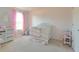 Charming Bedroom with crib, changing table, and window at 181 Silver Maple Bnd, Davenport, FL 33837