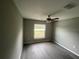 Simple bedroom with grey walls, vinyl flooring and ceiling fan at 142 Malauka Pass, Ocklawaha, FL 32179