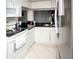 Kitchen with white cabinets, black countertops, and appliances at 435 Caribbean Dr, Davenport, FL 33897