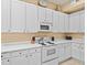 Kitchen features white cabinets, white appliances, and ample counter space at 401 New Providence Promenade # 12401, Davenport, FL 33897
