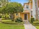 Front entrance of a two-story yellow home with landscaping and walkway at 401 New Providence Promenade # 12401, Davenport, FL 33897