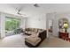 Bright living room featuring a large sectional sofa and access to a private balcony at 8810 Dunes Ct # 203, Kissimmee, FL 34747