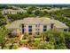 Exterior view of a two-story condo building with palm trees and landscaping at 8810 Dunes Ct # 203, Kissimmee, FL 34747