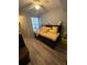 Bedroom with daybed, yellow bedding, and wood flooring at 4301 Lizshire Ln # C-109, Orlando, FL 32822