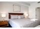 King-size bed, wood headboard, and modern wall art in a bright bedroom at 8763 Worldquest Blvd # 5406, Orlando, FL 32821