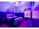 Unique bedroom with dark purple walls, a comfortable bed, and themed artwork at 315 Lucaya Loop # 315, Davenport, FL 33897
