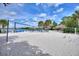 Sandy beach area with a volleyball net, tiki huts, and lounge chairs at 315 Lucaya Loop # 315, Davenport, FL 33897