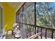 A screened balcony with two chairs and a small table overlooking lush trees at 315 Lucaya Loop # 315, Davenport, FL 33897