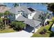 Two-story house with a gray roof, solar panels, and a carport, situated by a lake at 12212 Shadowbrook Ln, Orlando, FL 32828