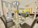 Bright dining room with glass table and gray chairs, adjacent to living area at 4805 Clock Tower Dr, Kissimmee, FL 34746
