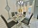 Elegant dining room showcasing a glass table and gray chairs at 4805 Clock Tower Dr, Kissimmee, FL 34746