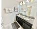 Double vanity bathroom with granite countertop and large mirror at 4805 Clock Tower Dr, Kissimmee, FL 34746