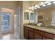Double vanity bathroom with granite countertops and access to a patio at 1424 Rolling Fairway Dr, Davenport, FL 33896