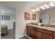 Double vanity bathroom with granite countertop and decorative artwork at 1424 Rolling Fairway Dr, Davenport, FL 33896