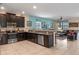 Open kitchen with dark cabinets, stainless steel appliances, and granite countertops at 1424 Rolling Fairway Dr, Davenport, FL 33896