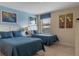Two twin beds in a bright bedroom with blue and tan color scheme at 1424 Rolling Fairway Dr, Davenport, FL 33896