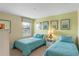 Bedroom with two twin beds, light teal bedding, and artwork at 1424 Rolling Fairway Dr, Davenport, FL 33896