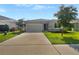 Newly constructed home with gray exterior, two-car garage, and landscaped lawn at 273 Summershore Dr, Auburndale, FL 33823