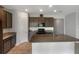 Modern kitchen with dark brown cabinets, granite countertops, and stainless steel appliances at 273 Summershore Dr, Auburndale, FL 33823