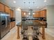 Island kitchen with granite countertops, stainless steel appliances, and light wood cabinets at 14198 Alafaya Oak Bnd, Orlando, FL 32828