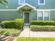 Green two-story townhome with a private entrance and well-manicured landscaping at 10888 Eclipse Lily Way # 62A, Orlando, FL 32832