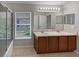 Double sink bathroom with a large window and updated lighting at 10888 Eclipse Lily Way # 62A, Orlando, FL 32832
