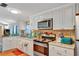 Modern kitchen with white cabinets, granite countertops, and stainless steel appliances at 1825 Ruby St, Lakeland, FL 33815