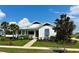 White house with blue accents, landscaped lawn, and walkway at 1077 Sugar Loaf Key Loop, Lady Lake, FL 32159