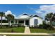 White house with blue accents, landscaped lawn, and walkway at 1077 Sugar Loaf Key Loop, Lady Lake, FL 32159
