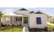 White house with blue accents, a porch, and landscaped yard at 1077 Sugar Loaf Key Loop, Lady Lake, FL 32159