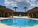 Large community pool with two gazebos and lush landscaping at 5518 Metrowest Blvd # 207, Orlando, FL 32811