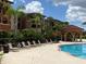 Community pool with adjacent lounge chairs and building view at 5518 Metrowest Blvd # 207, Orlando, FL 32811