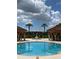 Resort-style pool with palm trees, fountains, and cabanas at 5518 Metrowest Blvd # 207, Orlando, FL 32811