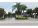 Gated community entrance with palm trees and landscaping at 3514 Victoria Pines Dr # 148, Orlando, FL 32829