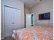 Bedroom with a double door closet and patterned bedding at 8887 Qin Loop, Kissimmee, FL 34747