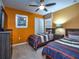 Bedroom with twin beds and orange accent wall at 8887 Qin Loop, Kissimmee, FL 34747