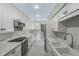 Renovated kitchen with white shaker cabinets, quartz counters, and stainless steel appliances at 311 E Morse Blvd # 7-2, Winter Park, FL 32789