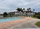 Community pool with brick patio, surrounded by lush landscaping and residential buildings at 5525 Pga Blvd # 4614, Orlando, FL 32839